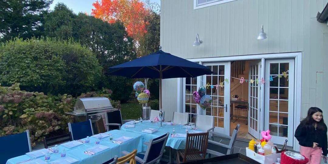 WechatIMG1969 Backyard hibachi party setup with grill, table seating, and birthday decorations before guests arrive