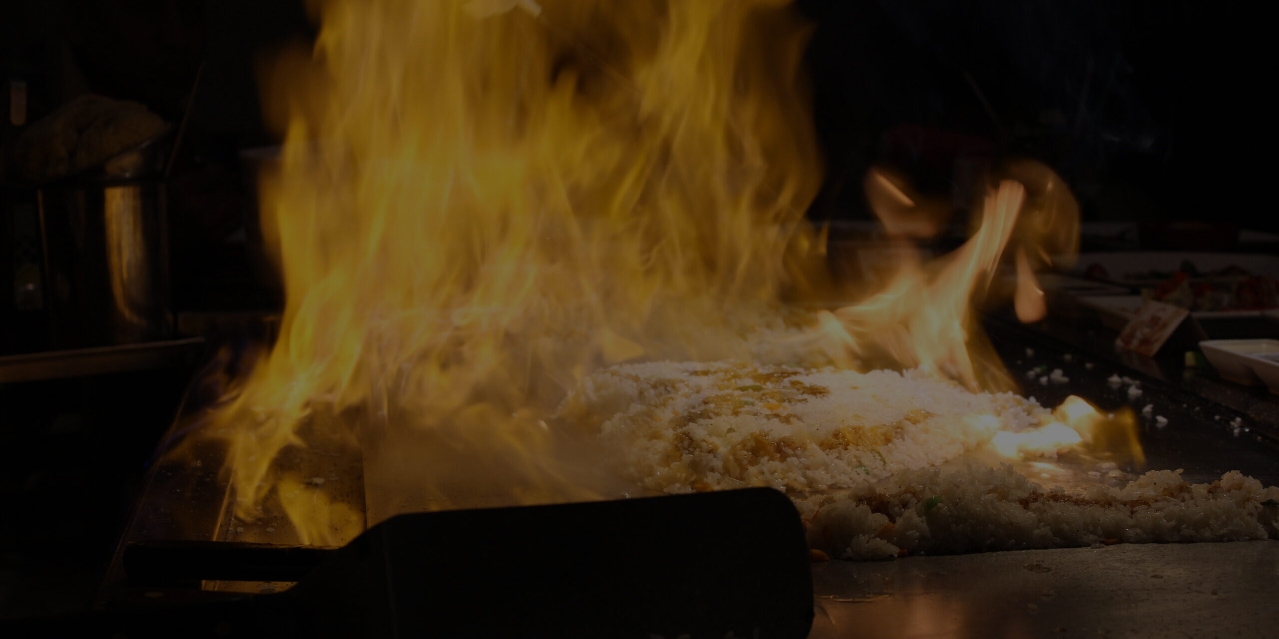 Guests seated around a hibachi grill during an at-home hibachi catering event