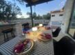 Covered patio dining setup prepared for an at-home hibachi party with table settings and outdoor seating