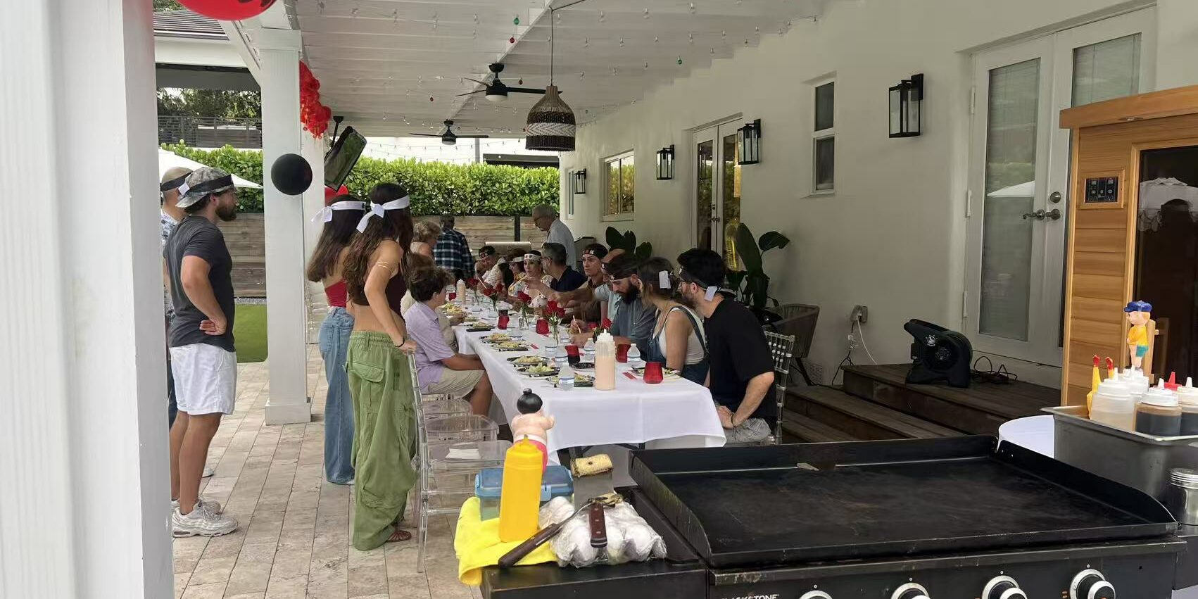 hibachiroyal-indoor-vs-outdoor-hibachi-party-planning Covered patio hibachi party setup with grill and guest seating for indoor vs outdoor at-home event planning