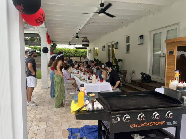Covered patio hibachi party setup with grill and guest seating for indoor vs outdoor at-home event planning