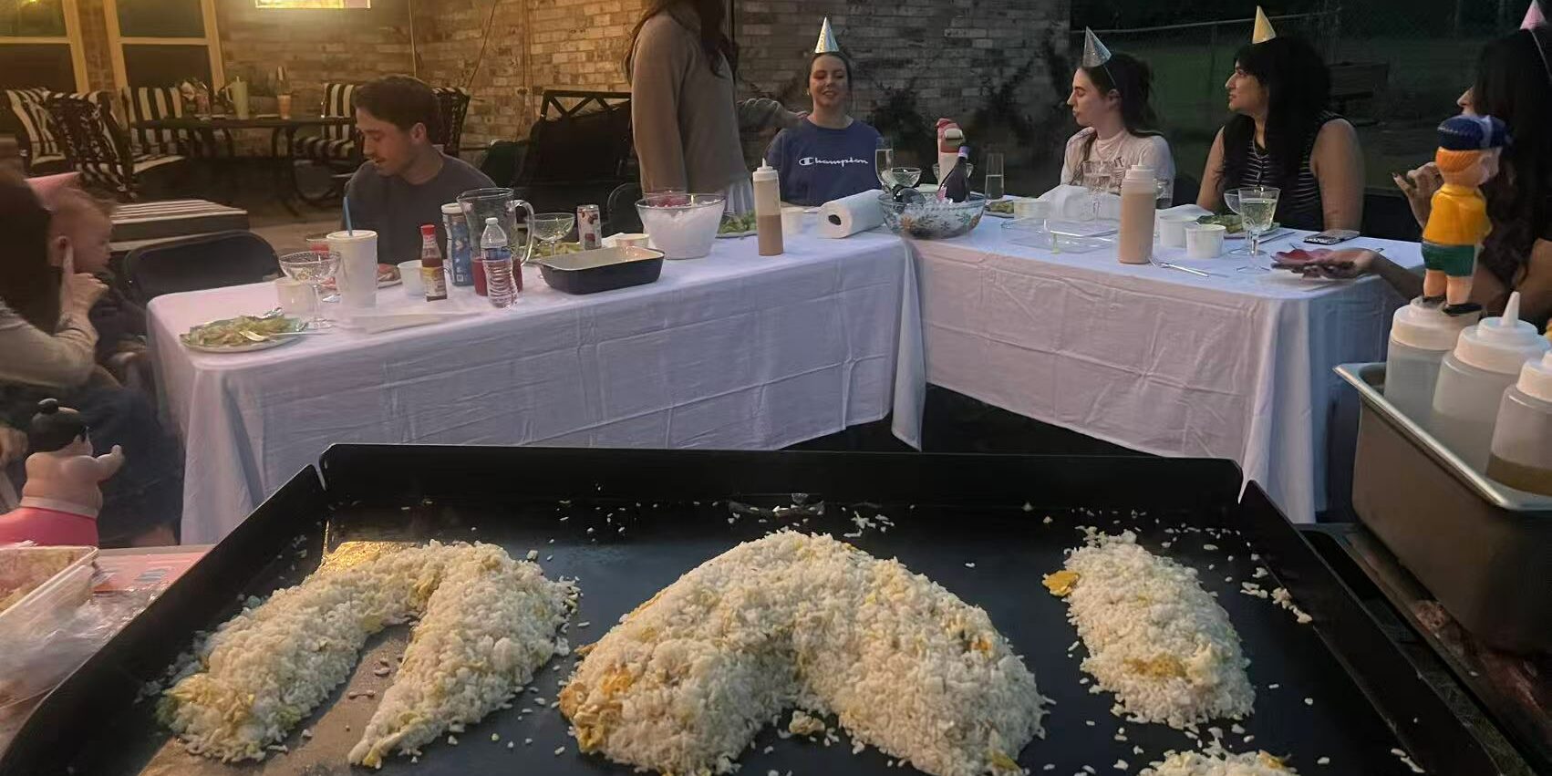 Private hibachi chef serving a signature hibachi party menu with steak, shrimp, and fried rice at an at-home dinner Private hibachi chef serving a signature hibachi party menu with steak, shrimp, and fried rice at an at-home dinner
