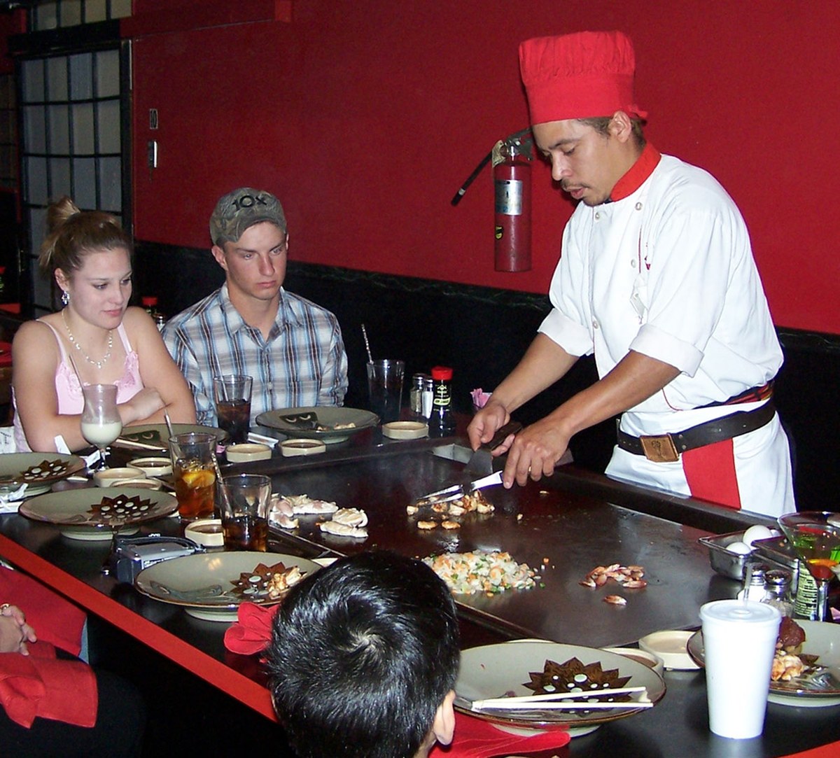 Hibachi dinner table at a teppanyaki restaurant with chef-grilled dishes served in front of guests